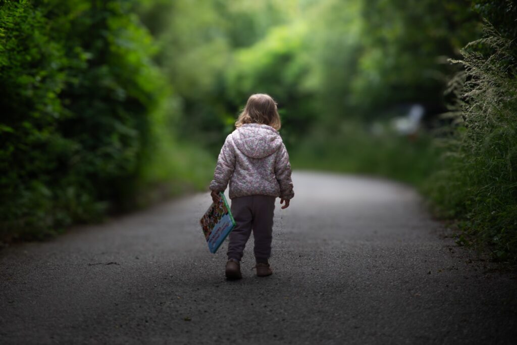 Kid walking with a book.